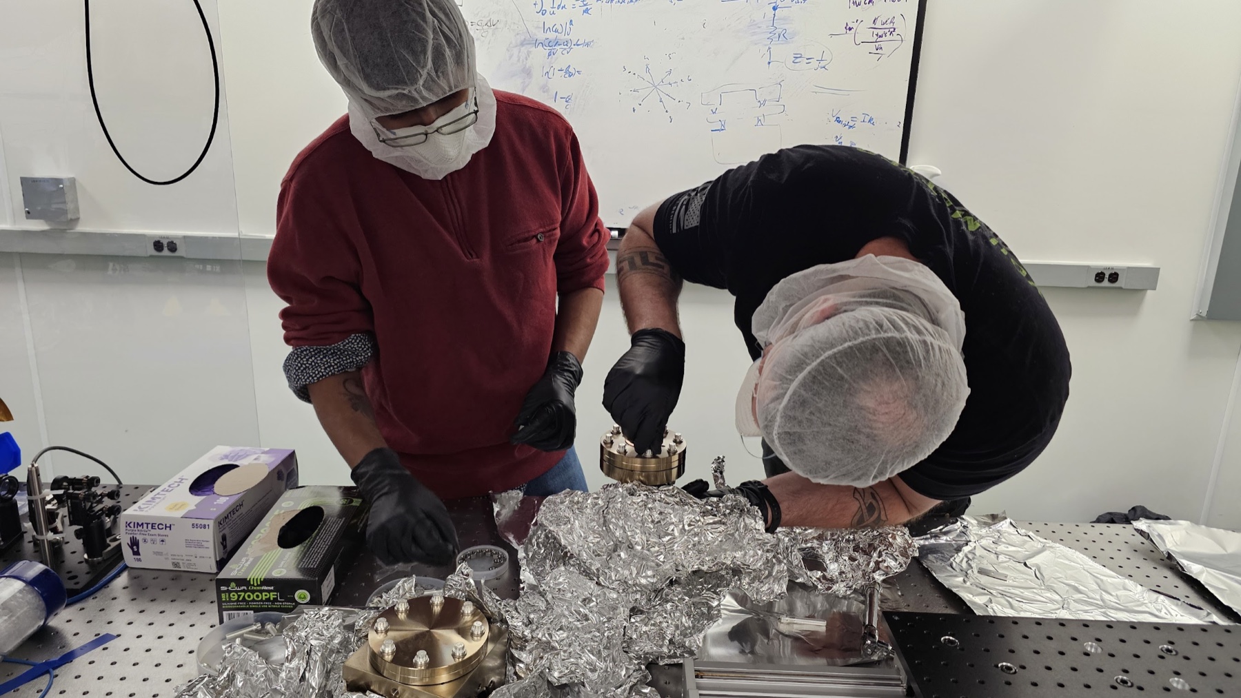 Team members assembling the vacuum chamber in March 2025.